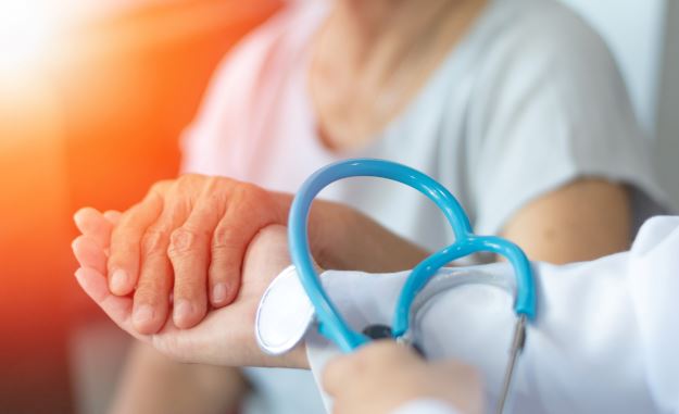 Geriatric physician holding a woman's hand