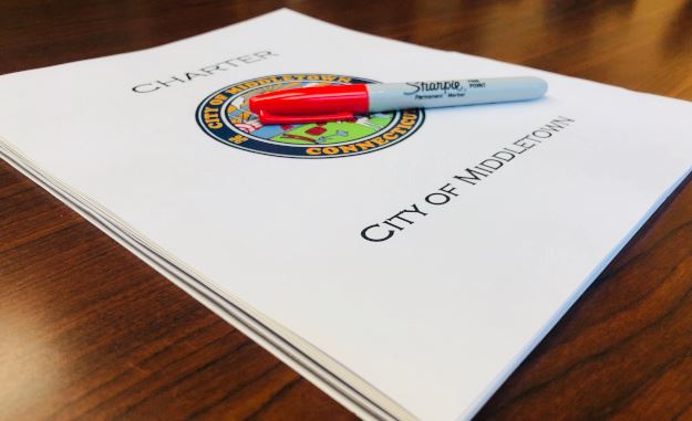 Picture of the Middletown City Charter and a pen